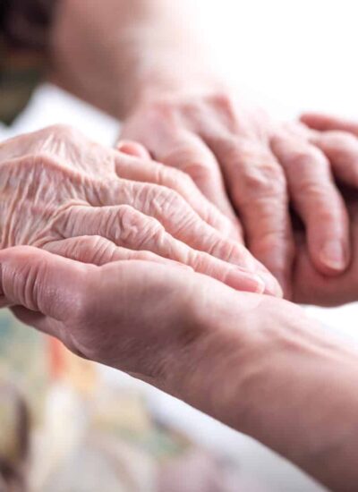 Hands of young woman holding the hands of an elderly person