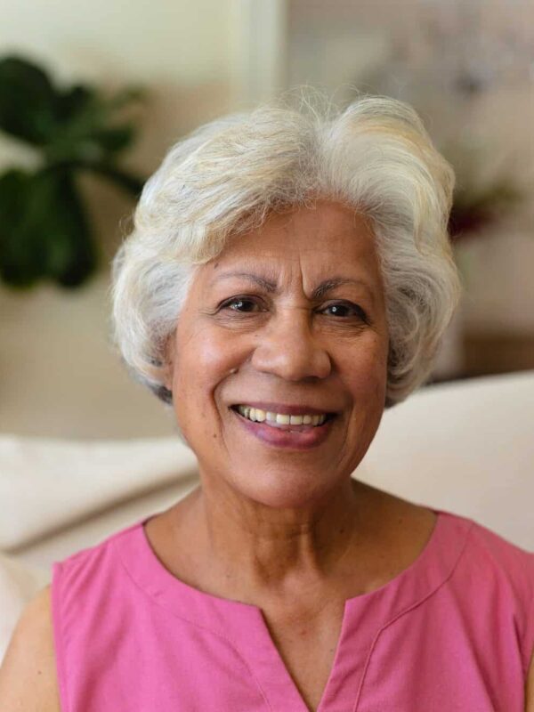 Portrait of african american senior woman smiling sitting on the couch at home
